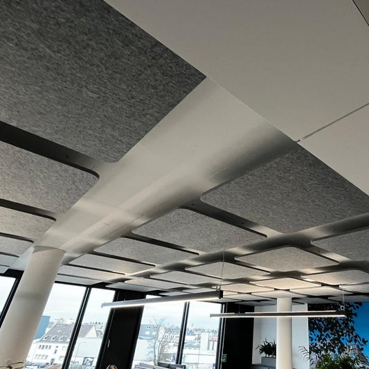 Acoustic ceiling islands Square above workplaces in an office space
